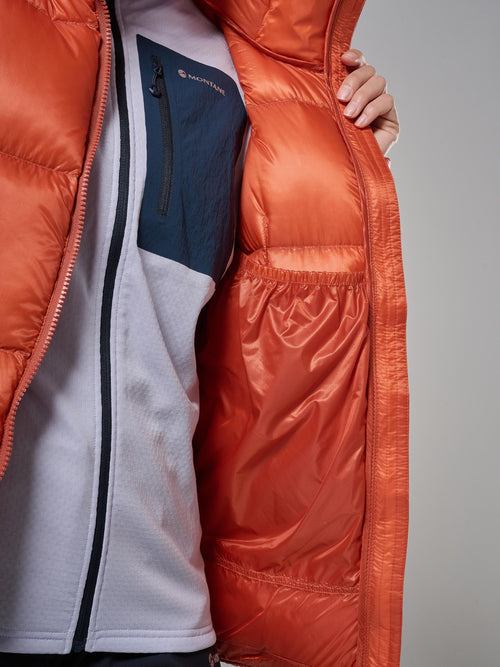 Person wearing a red puffer jacket with a visible brand logo on a neutral background