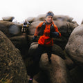 Runner wearing Montane Minimus Lite waterproof running jacket in lava